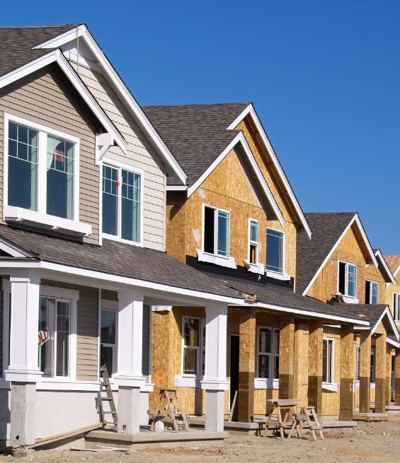 Row of new houses under construction featuring custom millwork for residential developments.