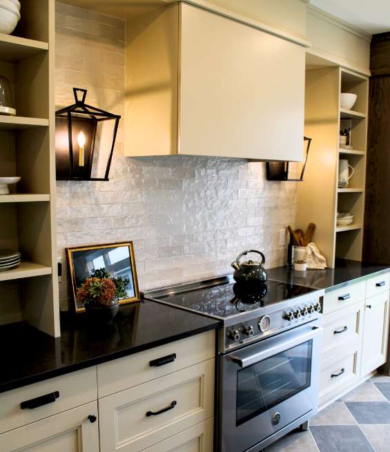 Modern kitchen featuring cream cabinets and black countertops from a professional kitchen cabinet supplier.