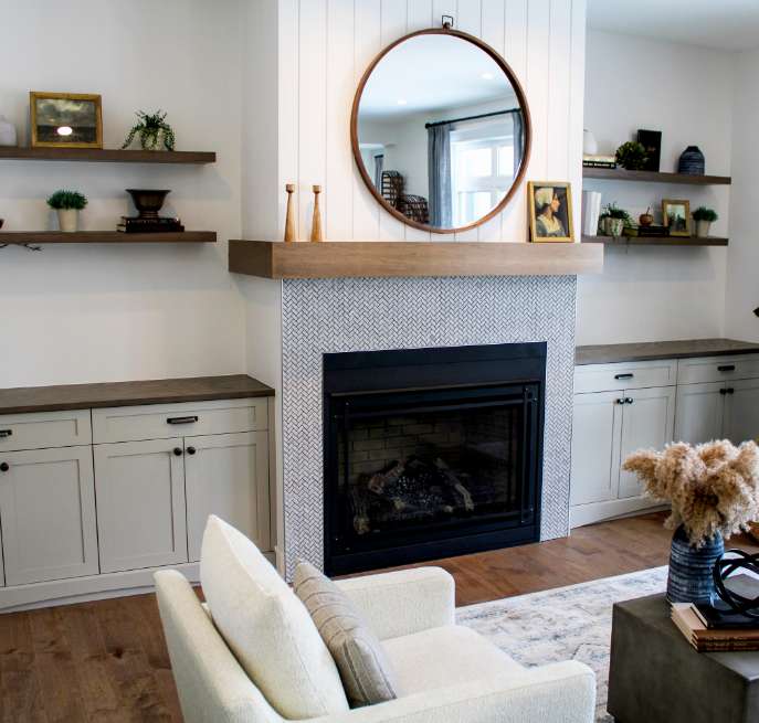 A modern wood mantel and custom millwork fireplace surround with decorative built-in cabinetry.